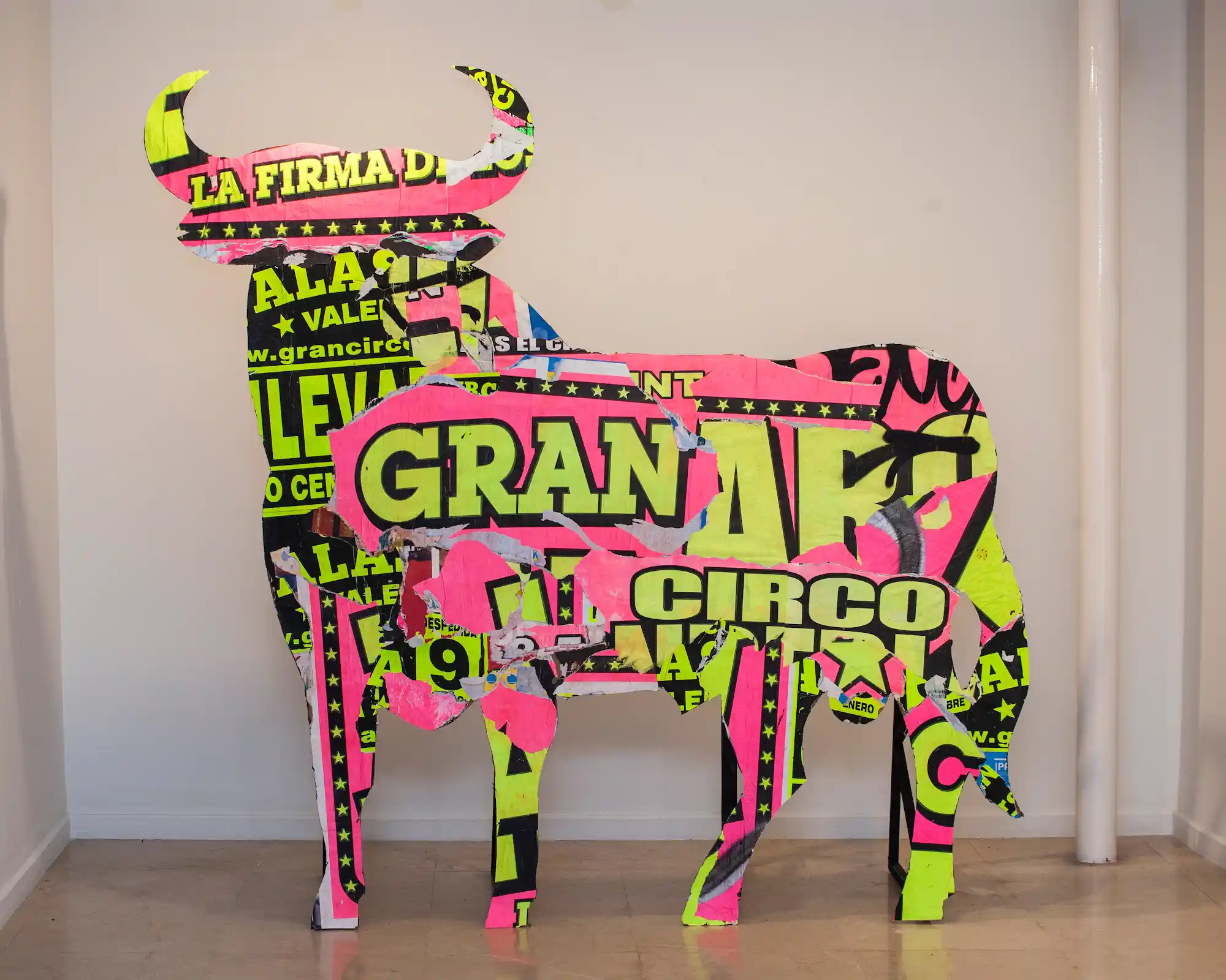 Figura de toro decorada con recortes de carteles de circo